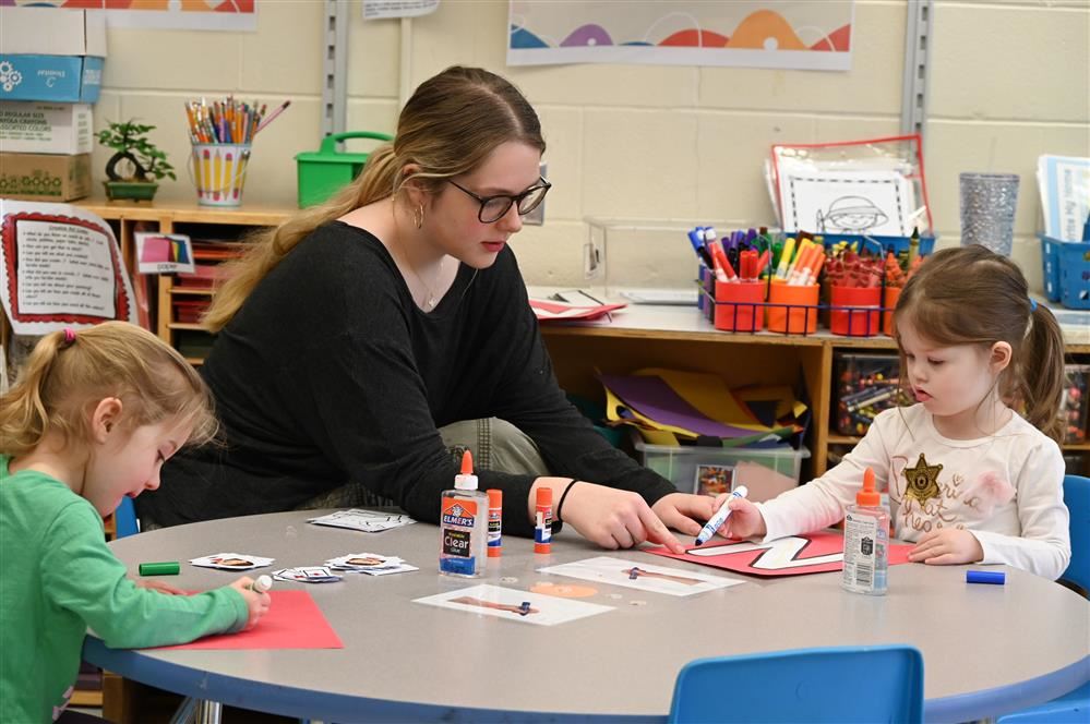 EMCC student and Teens-N-Tots Preschooler point to a date on the class calendar EMCC student and Teens-N-Tots Preschooler point to a date on the class calendar